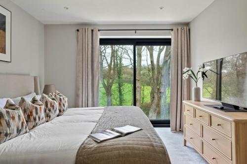 a bedroom with a bed and a large window at Finest Retreats - Orchard Rise in Bude