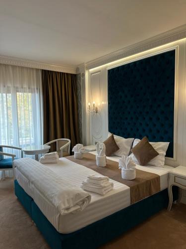 a bedroom with a large bed with a blue headboard at Cardinale Resort in Iaşi