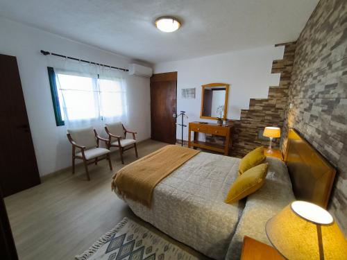 a bedroom with a large bed and a table and chairs at Casa Chemar in La Orotava