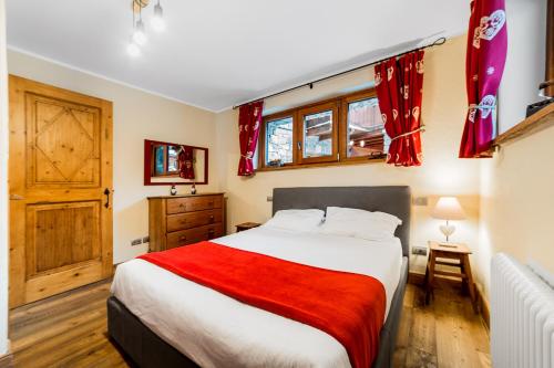 a bedroom with a bed with a red blanket at Maison Carrel Elegant 2 in Breuil-Cervinia
