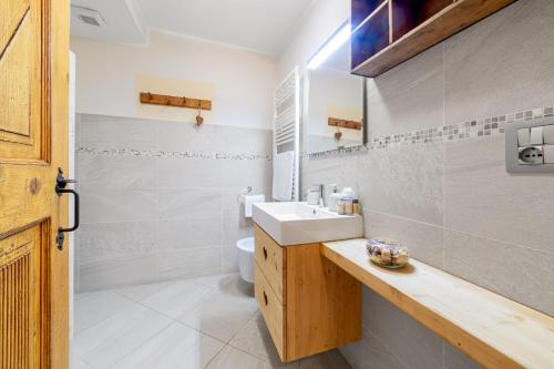 a white bathroom with a sink and a toilet at Maison Carrel Elegant 2 in Breuil-Cervinia