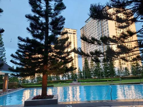 two pine trees in front of a building at Crystal Suites I Partial Taal View in Sampong