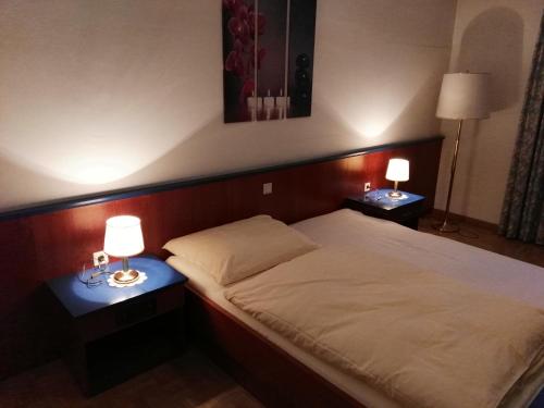 a bedroom with a bed with two lamps on tables at Hotel Seltenriegel in Wies