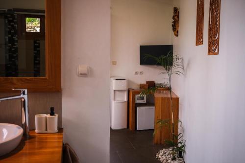 a kitchen with a white refrigerator and a sink at EDEN Private Pool Suites and Panoramic Agung View - ADULT ONLY in Nusa Penida