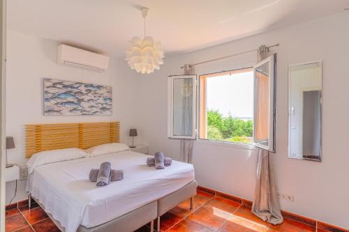 a bedroom with a bed and a window at Villa Betonia in Punta Prima