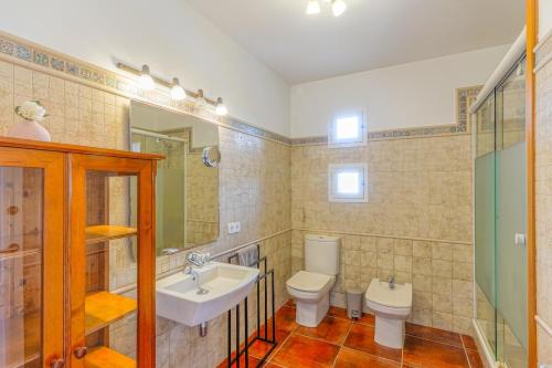 a bathroom with a sink and a toilet and a mirror at Villa Betonia in Punta Prima