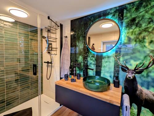 a bathroom with a mirror and a deer on the wall at Ferienwohnung Forest Life in Hasselfelde