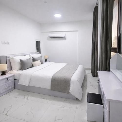 a white bedroom with a large bed in a room at Majd Lux Stay in Ma‘ābīlah