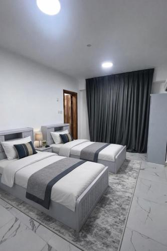 two beds in a hotel room with two beds sidx sidx sidx at Majd Lux Stay in Ma‘ābīlah