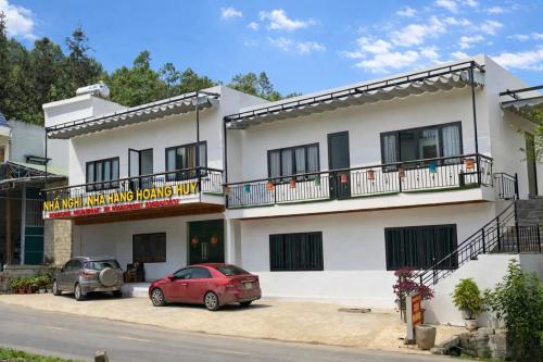 a building with two cars parked in front of it at À Lôi Homestay Đồng Văn in Dồng Văn