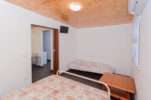 a bedroom with two beds and a wooden ceiling at Bed and Breakfast Brezza Marina 2 in Mattinata