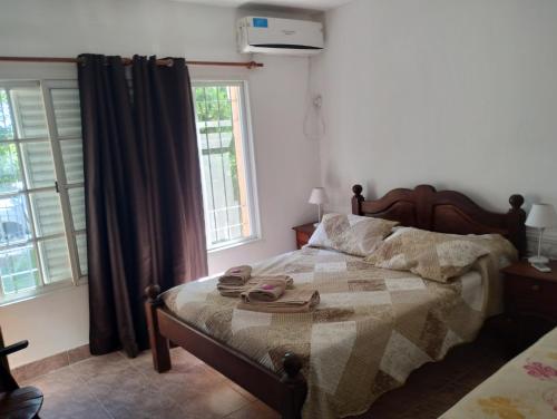a bedroom with a bed and two windows at JOAQUINA in Ramallo