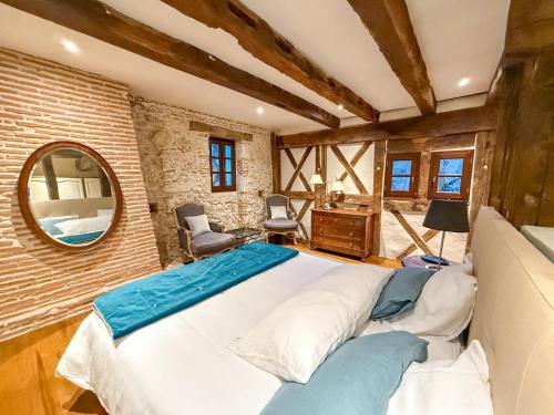a bedroom with a large bed and a mirror at LE CLOS DU BENESTAR in Mauvezin-dʼArmagnac