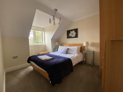 a bedroom with a large bed and a window at Spacious Bracknell Four Bedroom House in Bracknell