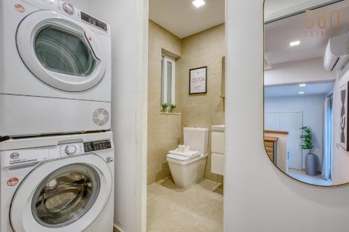 a bathroom with a washing machine and a toilet at 2BR Seafront Elegance with Balcony & Sea Views by 360 Estates in St. Paul's Bay