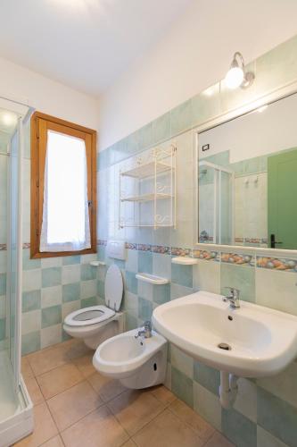 a bathroom with a sink and a toilet at Villa Le Palme 3 - 4 in Casa Buraccio