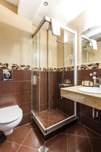 a bathroom with a shower and a toilet and a sink at City Avenue Hotel in Sofia