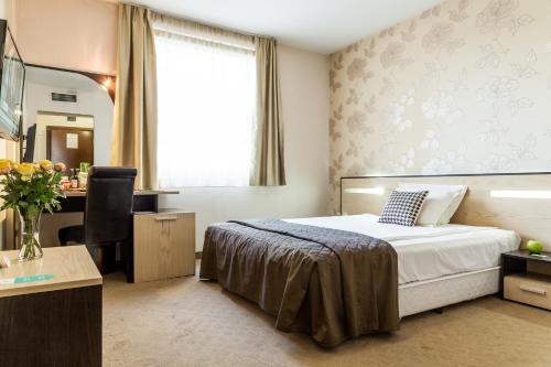 a hotel room with a bed and a desk at City Avenue Hotel in Sofia