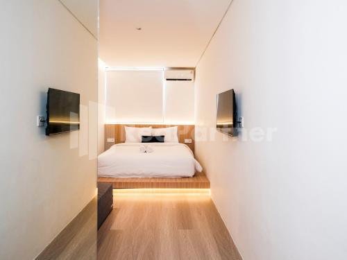 a bedroom with a white bed and a mirror at Mora Stay Demangan RedPartner in Yogyakarta