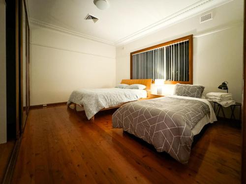 a bedroom with two beds and a window at Old Charm Guesthouse in Bass Hill