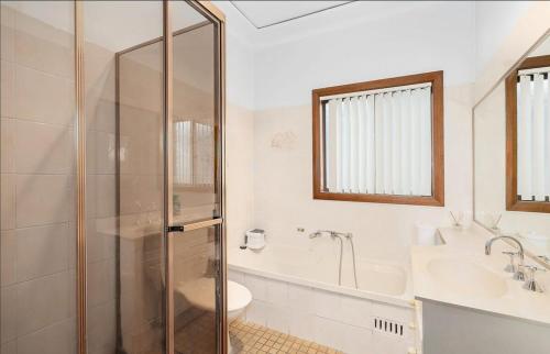 a bathroom with a shower and a sink and a toilet at Old Charm Guesthouse in Bass Hill