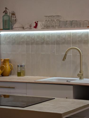 a kitchen with a sink and a shelf with glasses at Ca la Lola Estartit in L'Estartit