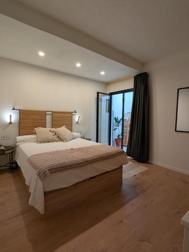 a bedroom with a large bed and a large window at Ca la Lola Estartit in L'Estartit