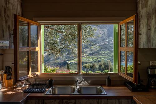 a kitchen with a sink and a large window at Villa lito in Zóla