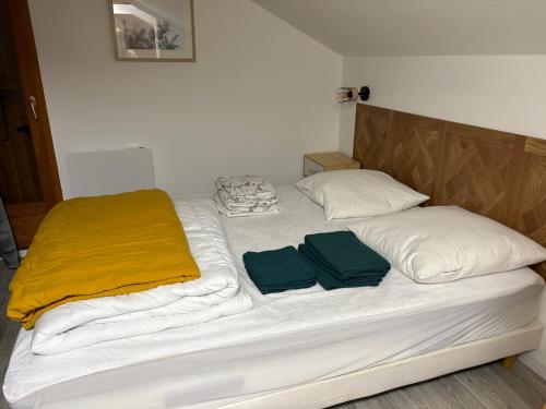 a bed with white sheets and two towels on it at Alpes Ski SUPERDEVOLUY in Le Dévoluy