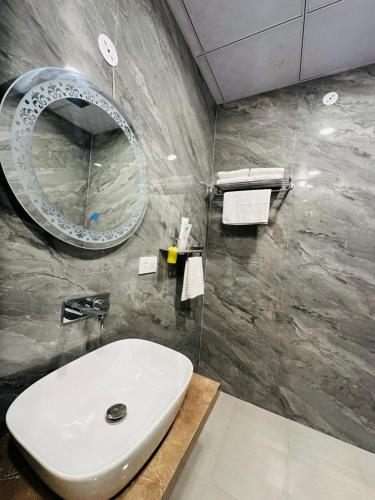a bathroom with a white sink and a mirror at Hotel The Maya Palace in Jaipur