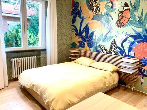 a bedroom with a bed and a mural of butterflies at Modern 90sqm Apt - Ideal Base for Parma & Modena in Cavriago