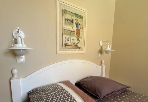 a bedroom with a bed and two lights on the wall at Au calme, appartement au cœur du Golf - Piscine in Talmont