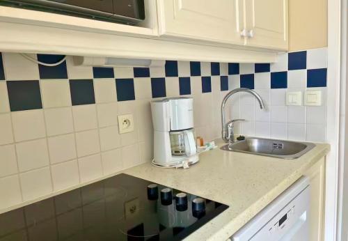 a kitchen with a sink and a coffee maker at Au calme, appartement au cœur du Golf - Piscine in Talmont