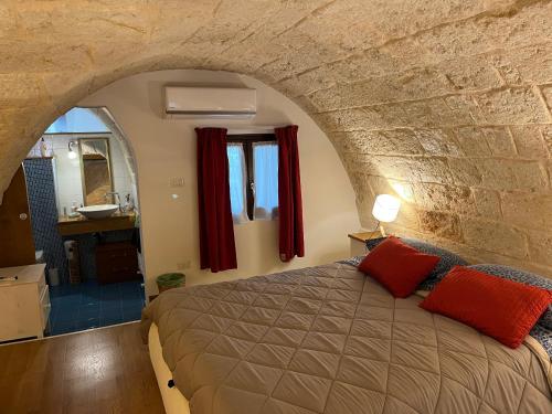a bedroom with a bed in a stone wall at Casa Mola di Bari in Mola di Bari
