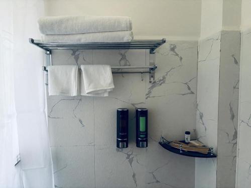 a bathroom with towels and a shelf with towels at Norbu Healing Hotel in Thimphu