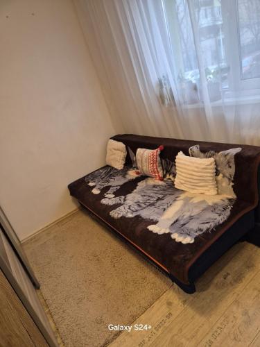 a brown couch sitting in a room with a window at ARTIFICII București in Bucharest