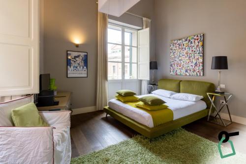 a bedroom with a bed and a couch and a window at Hotiday Cagliari Porto in Cagliari