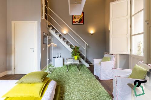a living room with a staircase and a green rug at Hotiday Cagliari Porto in Cagliari