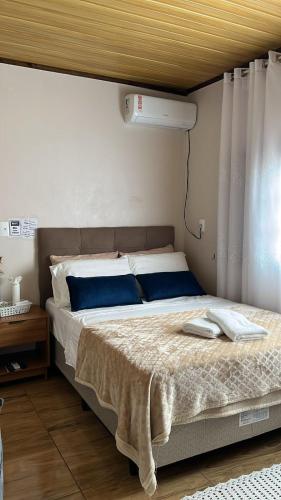a bedroom with a large bed with blue pillows at Pousada Nunes in Lauro Müller