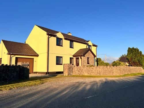 a yellow house on the side of a road at Ty'n Rardd mountain views secure garden parking in Beaumaris