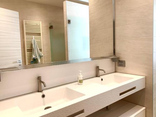 a bathroom with a sink and a mirror at Modern 90sqm Apt - Ideal Base for Parma & Modena in Cavriago
