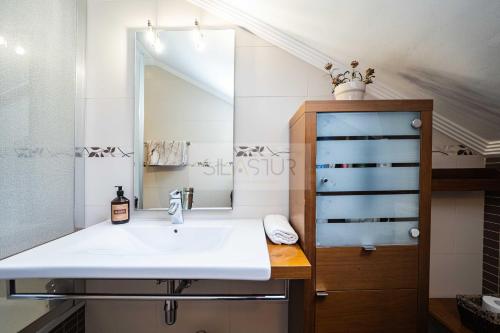 a bathroom with a sink and a mirror at La Casina Azul de May By Silastur in San Juan de la Arena