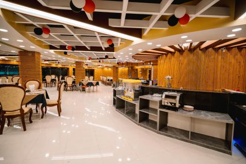 a dining room with tables and chairs in a restaurant at Royal Hotel Khulna - City Center in Khulna