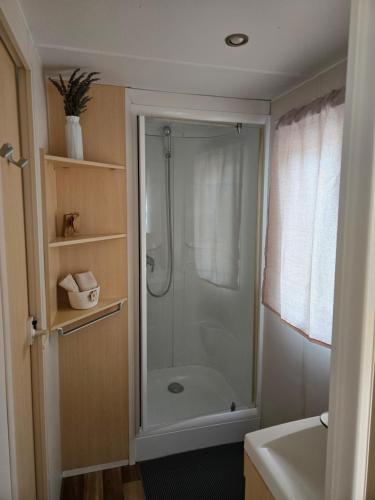 a bathroom with a shower with a glass door at Mobil-home Beau Rivage in Gunsbach