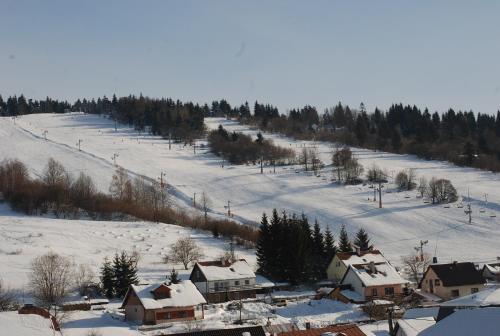 a snow covered hill with houses and a ski slope at Kolnicka Krahule in Krahule