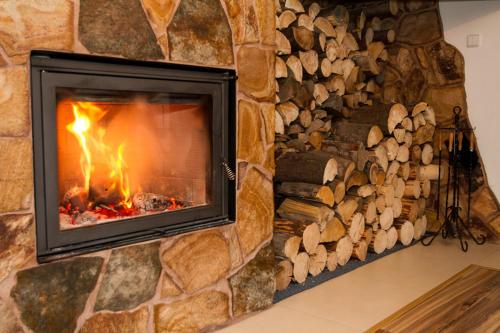 a stone fireplace with a fire in it at Kolnicka Krahule in Krahule