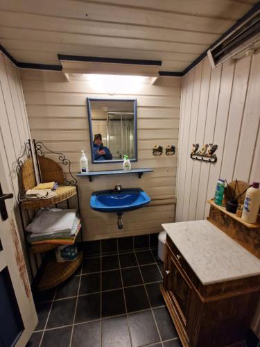 a bathroom with a blue sink and a mirror at The Old Cottage in Harstad