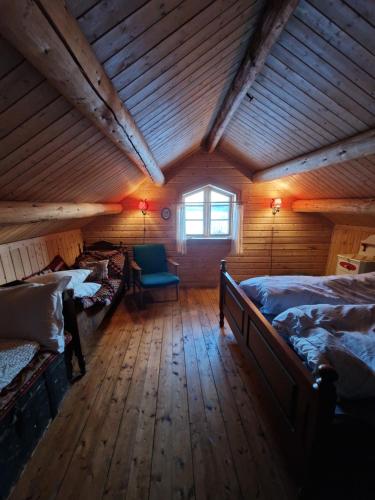 a attic room with two beds and a window at The Old Cottage in Harstad