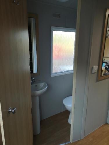 a bathroom with a sink and a toilet and a window at Csendàr hàz in Tapolca