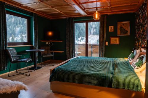 a bedroom with a green bed and a table and chairs at Haus Waldruhe in Mallnitz